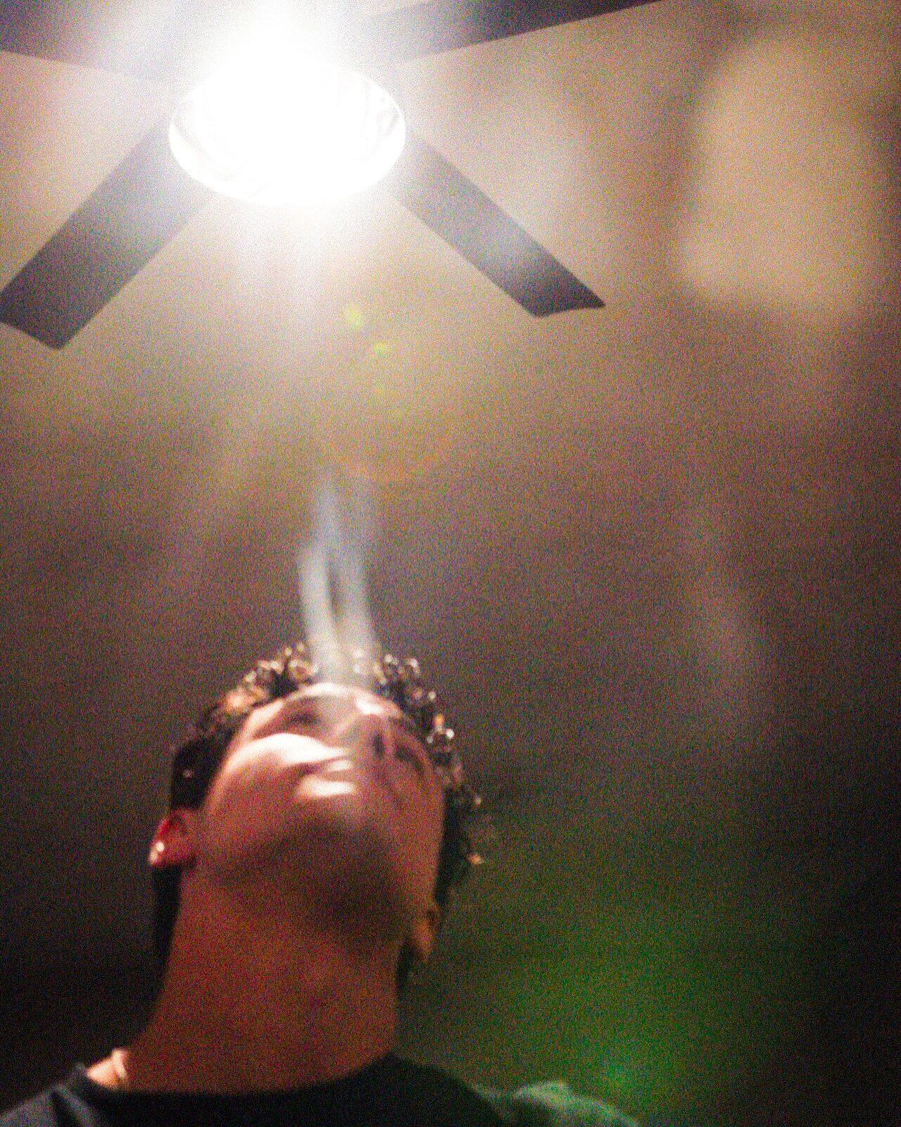Looking straight up at a ceiling fan and a bare bulb