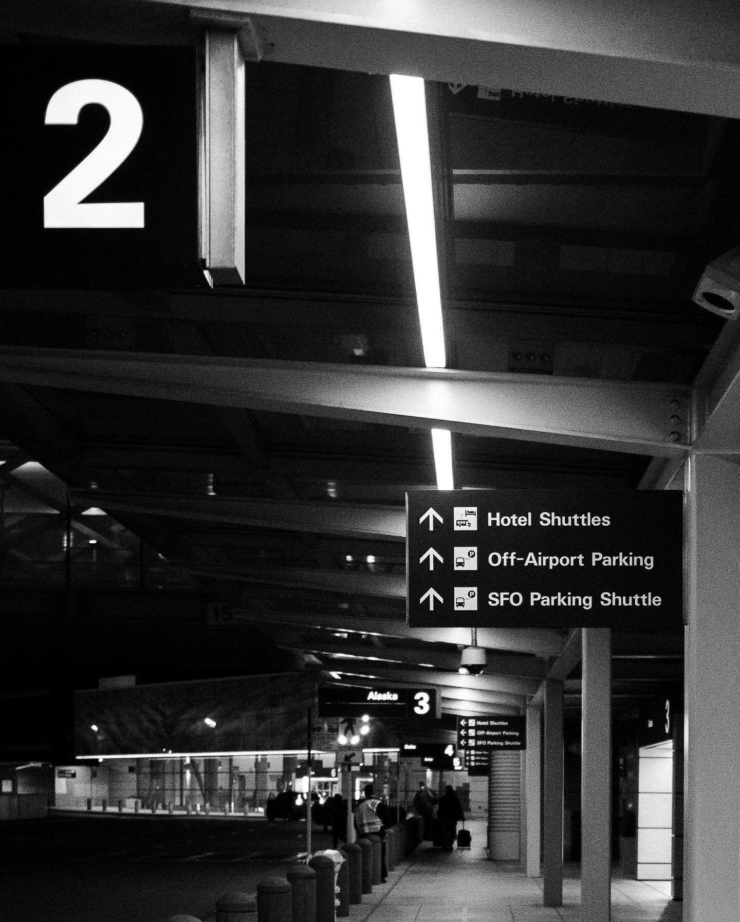 Level 2 of an airport parking garage, shuttle signs overhead