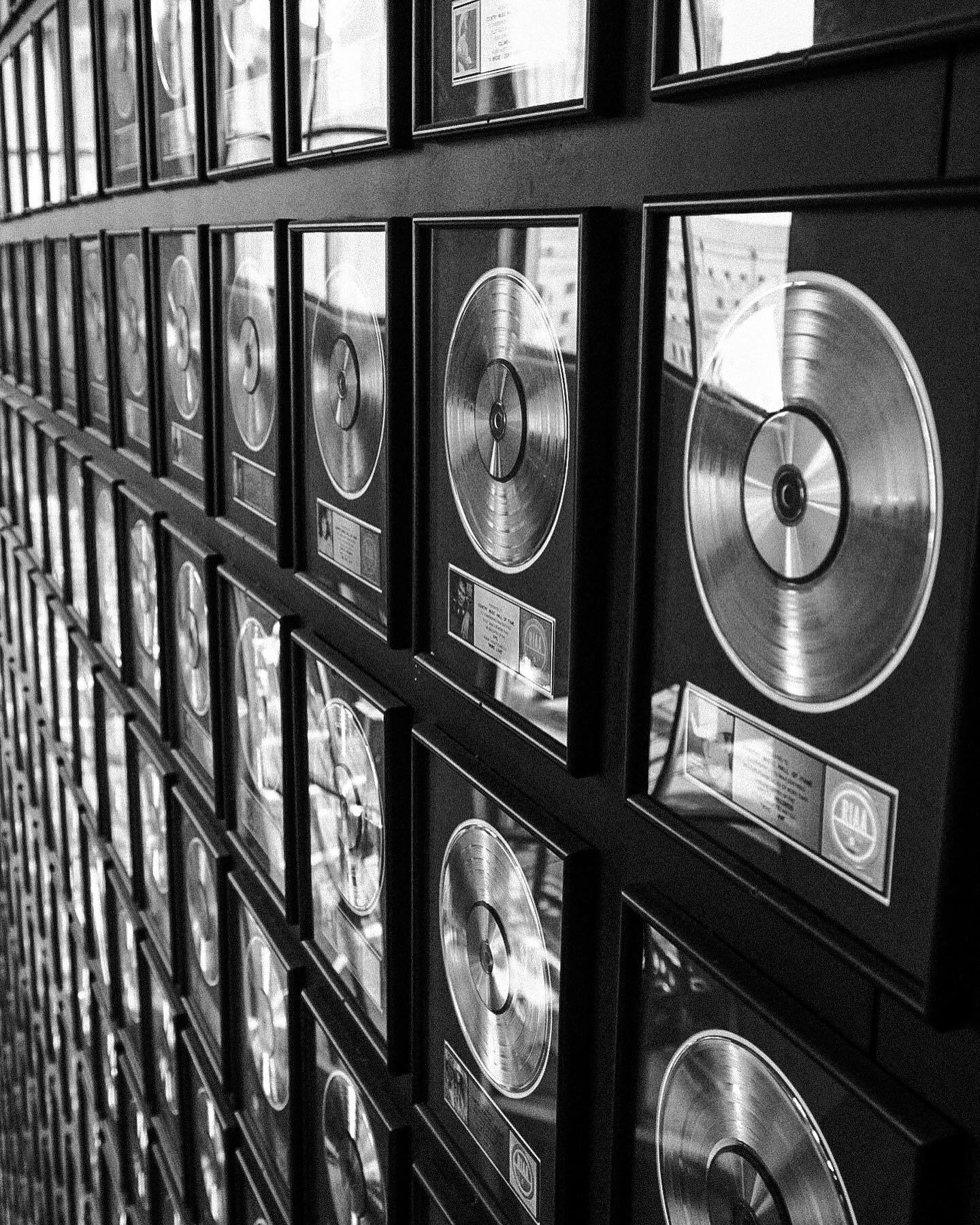 A wall of framed gold records receding at an angle