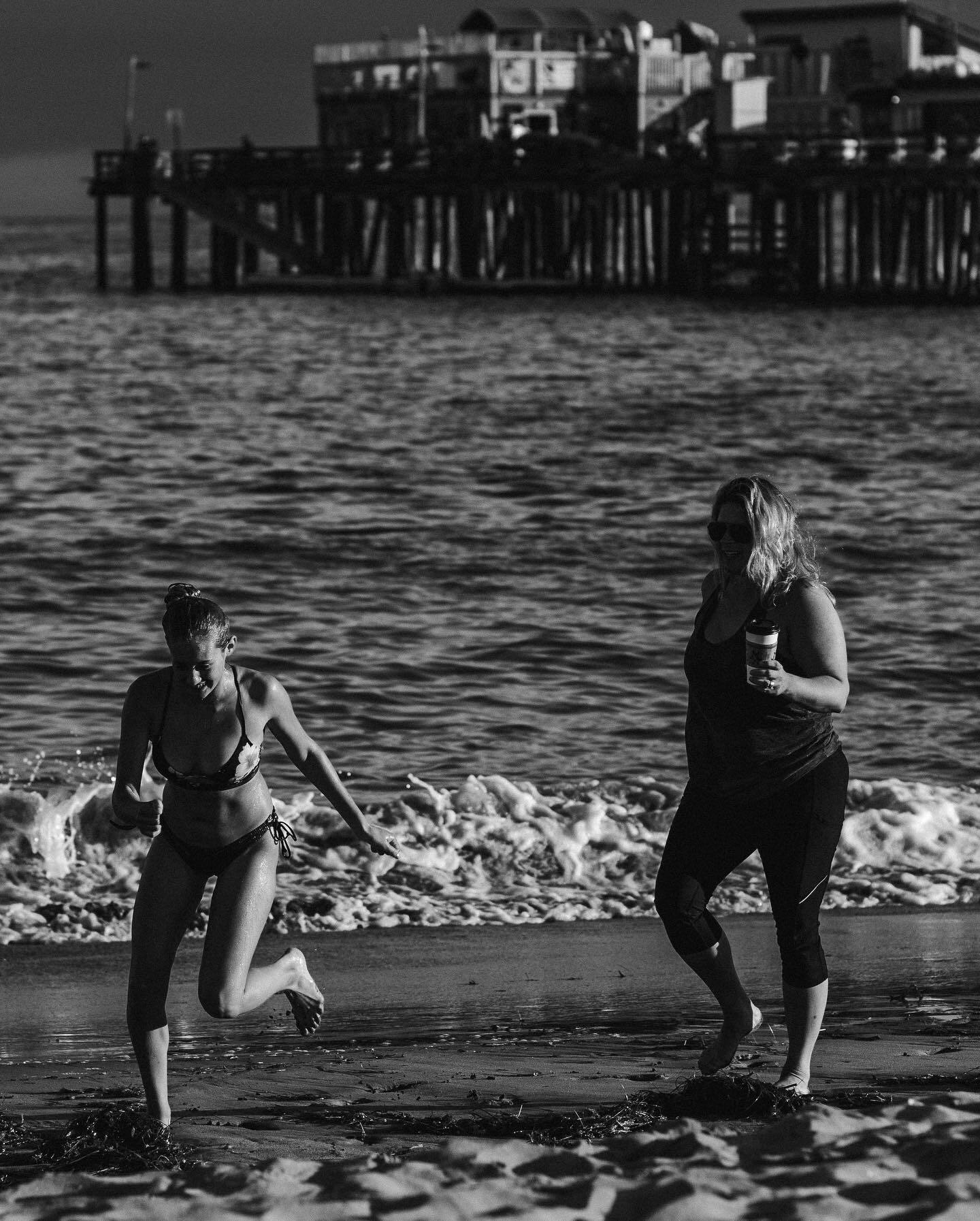 Two swimmers wading in at the shoreline